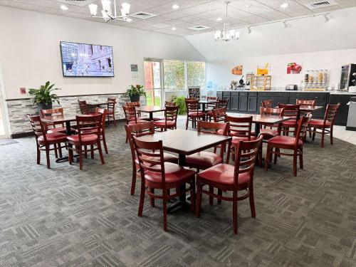 a restaurant with wooden tables and red chairs at Econo Lodge Wausau - Rothschild in Rothschild