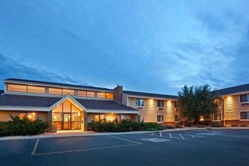 a large building with a parking lot in front of it at AmericInn by Wyndham Mitchell in Mitchell