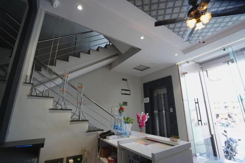 a living room with a staircase and a window at Hotel Vardhaman Inn in Yavatmāl