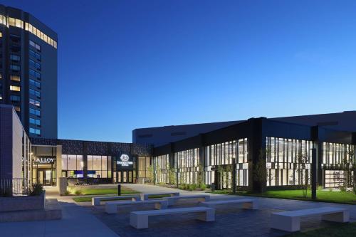 a campus with benches in front of a building at Doubletree By Hilton Battle Creek in Battle Creek