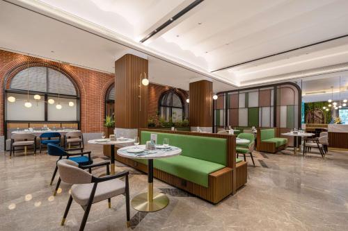 a restaurant with tables and chairs in a room at Hilton Garden Inn Shanghai Caoyang in Shanghai