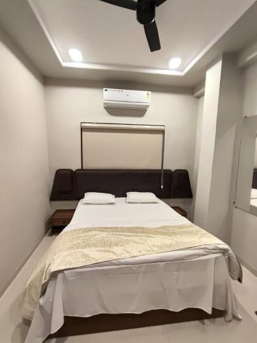 a bedroom with a bed with a ceiling fan at Hotel Vardhaman Inn in Yavatmāl
