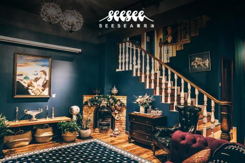 a living room with blue walls and a staircase at 深圳看见海海景精品民宿 in Shenzhen