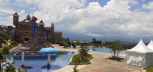 a resort with a swimming pool and a building at RAM Homestay Sharia, 5 Adults 1 Child, Ideal Stay Between Bromo & South Malang Beaches in Bareng
