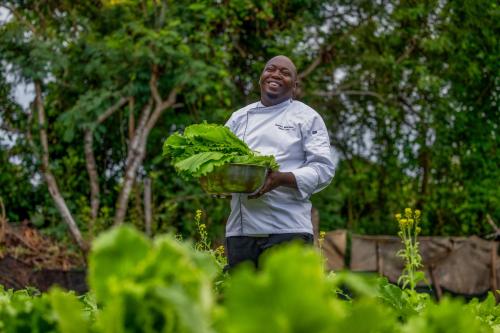 a man is holding a basket of lettuce at Kilindi Zanzibar in Kendwa