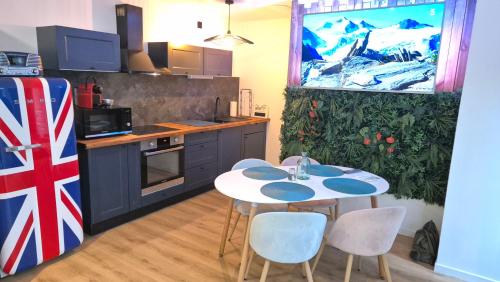 une cuisine avec une table et des chaises dans une cuisine dans l'établissement Balnéo Nuits Tranquilles Rouen, à Rouen