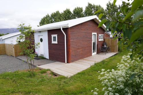 a small cabin with a wooden deck in a yard at Hlakot Cabin In Golden Circle in Mosfellsbær
