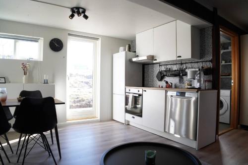 a kitchen with white cabinets and a table and a window at Hlakot Cabin In Golden Circle in Mosfellsbær