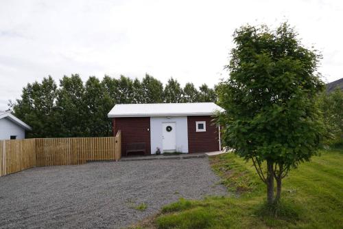a small garage with a fence and a tree at Hlakot Cabin In Golden Circle in Mosfellsbær