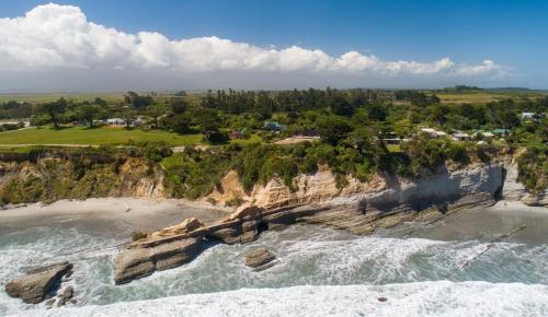 an aerial view of the ocean and a beach at the hole in the rock yurt in Cape Foulwind