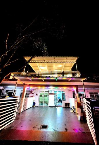a lit up building with a porch at night at Khalifah Homestay Penaga in Penaga