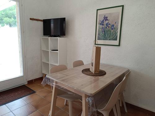 une table à manger avec des chaises et une télévision dans l'établissement T2 climatisé à 2 minutes de la plage du Pont Tournant - 4BRANB, à Saint Cyprien Plage