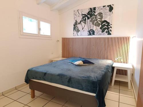 une chambre avec un lit avec une couette bleue dans l'établissement T2 climatisé à 2 minutes de la plage du Pont Tournant - 4BRANB, à Saint Cyprien Plage