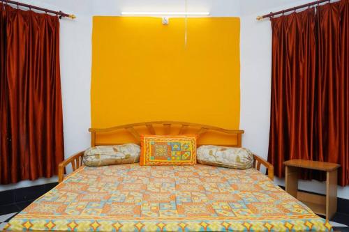 a bedroom with a bed with a yellow wall at Awadh Centrally located 1BR near Old Lucknow in Lucknow