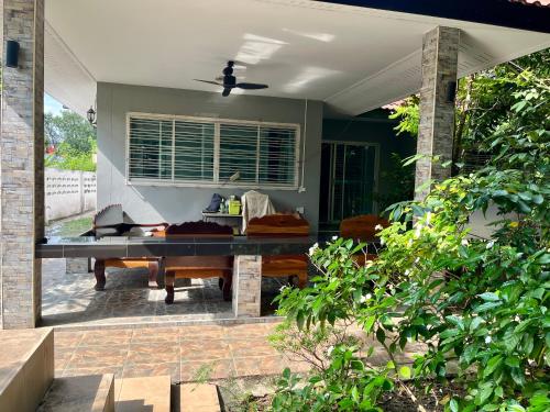 a screened in porch with a ping pong table at Kunaeng ครัวกันเอง รีสอร์ท in Ban Nong Pla Lai