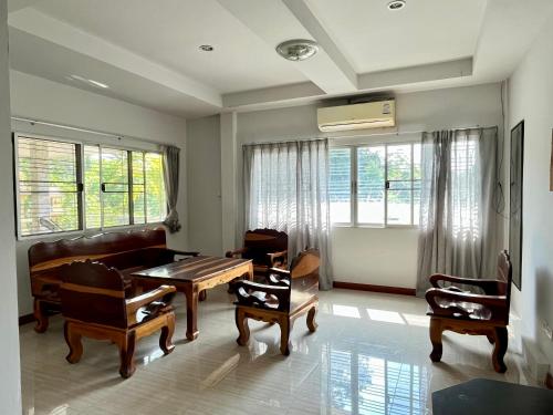 a living room with a couch and a table and chairs at Kunaeng ครัวกันเอง รีสอร์ท in Ban Nong Pla Lai