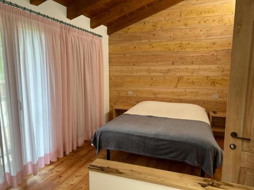 a bedroom with a bed in a room with wooden walls at Locazione turistica Casa Delle Ceramiche in Brendola