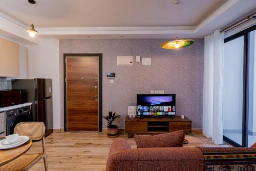 a living room with a couch and a television at Elite One Bedroom Apartment Westlands, Swimming pool, gym, workspace ,Wonderiss Properties close proximity to GTC, JW Mariott and Kempinski in Nairobi