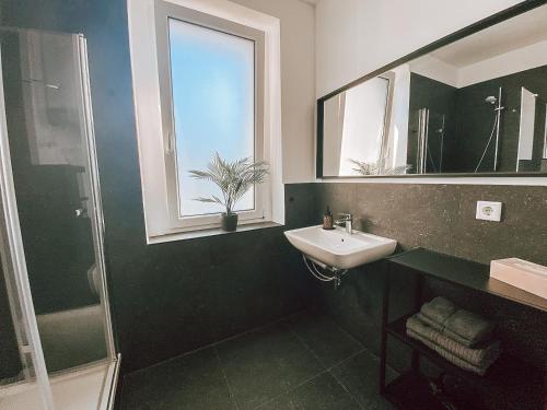 a green and white bathroom with a sink and a window at BetterBeds City - Apartments - Zentral - Smart TV - Küche - WLAN in Brandenburg an der Havel