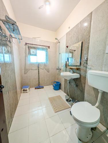 a bathroom with a toilet and a sink at Hobo Hostel in Dharamshala