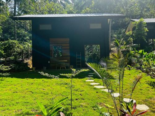 a small house in a field with a yard at Tiny Hideaway Luna House with free 2 motorbikes in El Nido