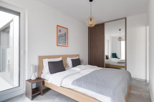 a bedroom with a large bed and a mirror at Poznań Apartments Towarowa in Poznań