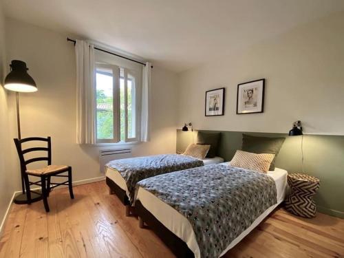 une chambre avec deux lits et une chaise et une fenêtre dans l'établissement Villa Casa Manuela au Moulleau PYLA SUR MER, à Arcachon