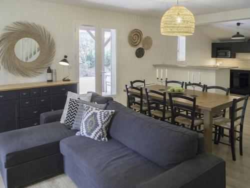 un salon avec un canapé bleu et une table dans l'établissement Villa Casa Manuela au Moulleau PYLA SUR MER, à Arcachon