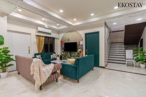 a living room with two couches and a tv at EKOSTAY - Amanta Hills 7BHK in Karjat