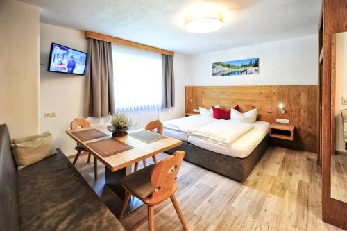pokój hotelowy z łóżkiem i stołem w obiekcie Bäckerei Schranz w mieście St. Leonhard im Pitztal
