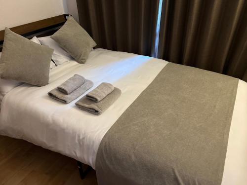 a bed with two towels and two pillows on it at メゾンド天神 in Fukuoka