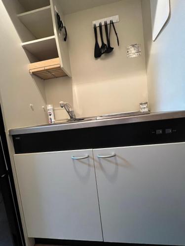 a kitchen with white cabinets and a sink at メゾンド天神 in Fukuoka
