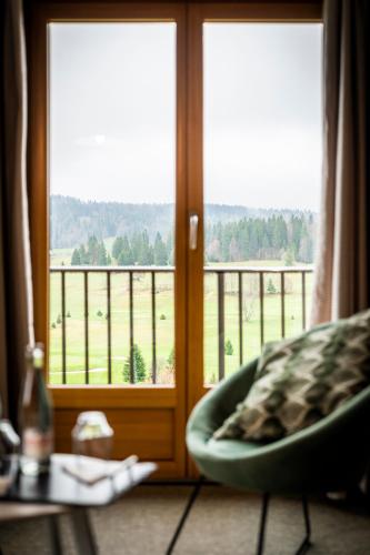 a room with a chair in front of a window at Domaine du Mont-Saint-Jean in Les Rousses