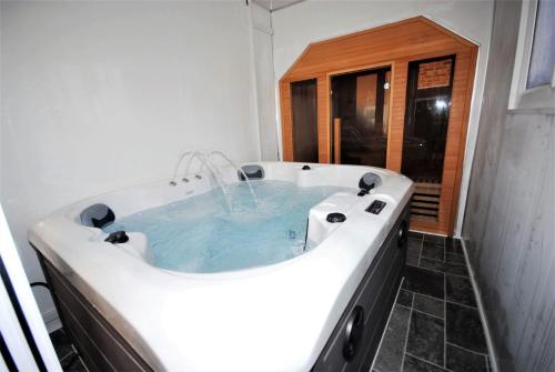 un jacuzzi dans une salle de bain avec une fenêtre dans l'établissement Cozy Hideaway With Hot Tub Sauna Sleeps 7, à Falmer