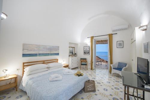 une chambre avec un grand lit et une télévision dans l'établissement Casa di Nonno Mario, à Praiano