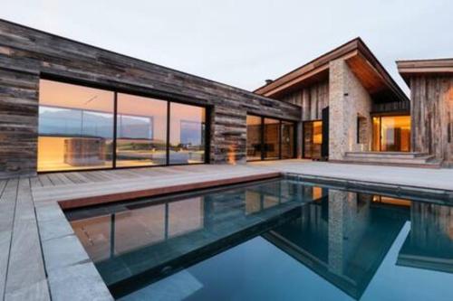 une maison avec une piscine devant dans l'établissement Villa Wooden Horizon - Mer Montagne 18 pers, à Porto-Vecchio