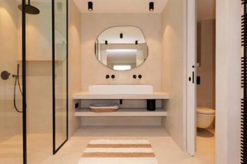 une salle de bain avec un lavabo et un miroir dans l'établissement Villa Wooden Horizon - Mer Montagne 18 pers, à Porto-Vecchio