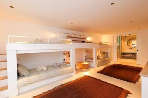 Cette chambre comprend un lit blanc et un canapé. dans l'établissement Villa Wooden Horizon - Mer Montagne 18 pers, à Porto-Vecchio