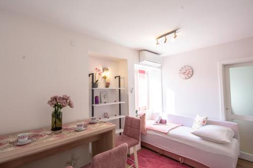 a room with a bed and a desk and a window at Apartments Fortuna in Novalja