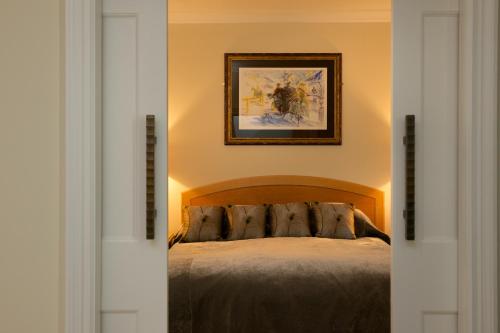 a bedroom with a bed and a painting on the wall at GreyFriars in Colchester