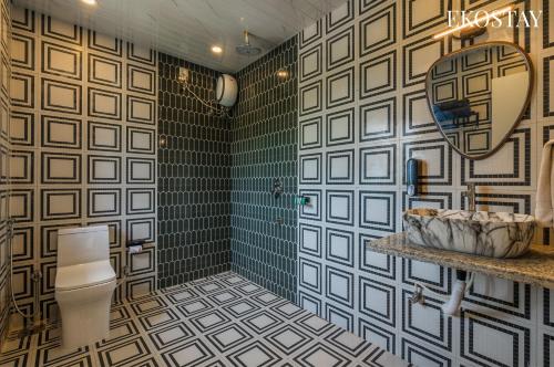 a bathroom with a toilet and a shower and a sink at EKOSTAY - Amanta Hills 7BHK in Karjat