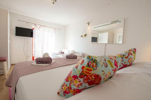 a bedroom with two beds and a mirror at Apartments Fortuna in Novalja