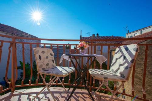 two chairs and a table on a balcony at Apartments Fortuna in Novalja