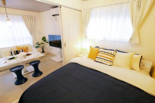 a bedroom with a large bed with yellow pillows at Stellar西糀谷202 in Tokyo