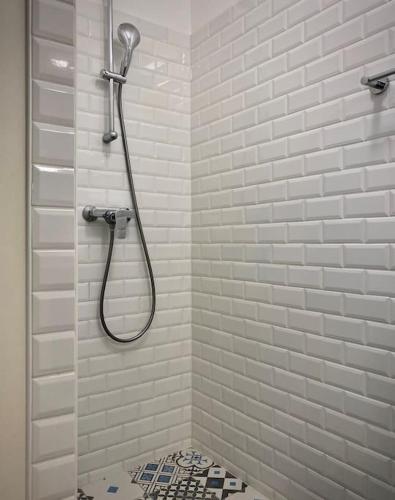 une douche dans une salle de bain avec du carrelage blanc dans l'établissement Villa Casa Julia au Moulleau PYLA SUR MER, à Arcachon