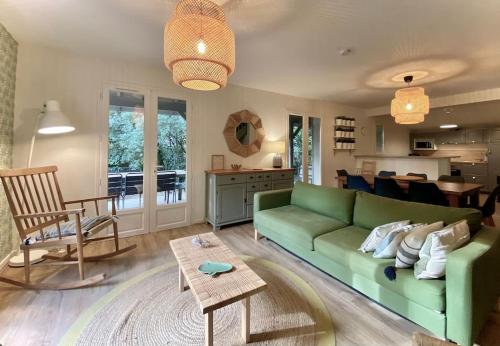un soggiorno con un divano verde e un tavolo di Villa Casa Julia au Moulleau PYLA SUR MER ad Arcachon