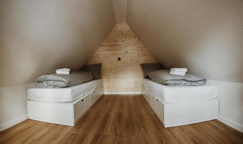 two beds in a room with a roof at Harzchalet Brockenbahn 2A in Elend