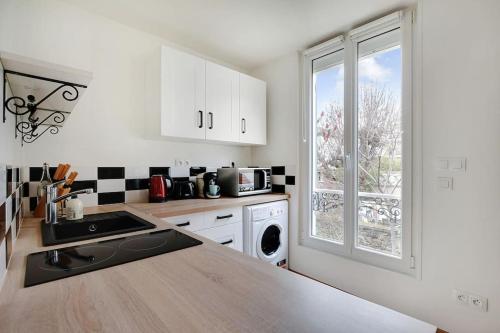 une cuisine avec un comptoir et une fenêtre dans l'établissement Magnifique studio neuf aux portes de Paris, à Charenton-le-Pont