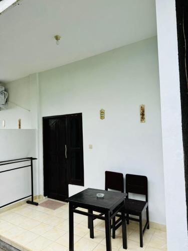 a black table and two chairs in a room at Biya Lumba in Candidasa