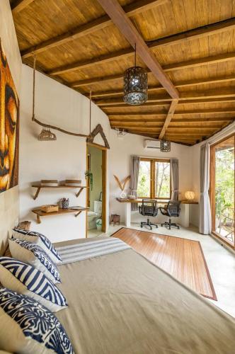 a bedroom with a large bed and wooden ceilings at Villa Capung Padang Padang in Uluwatu